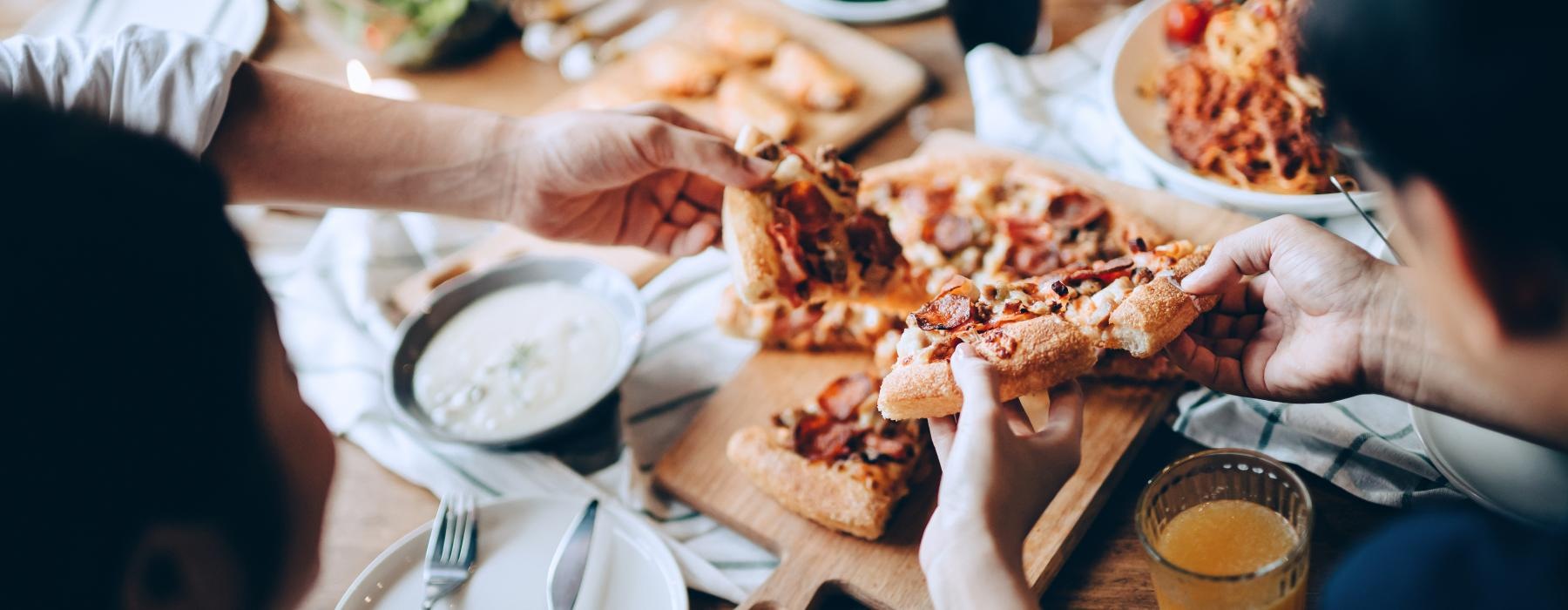 people eating pizza at a table