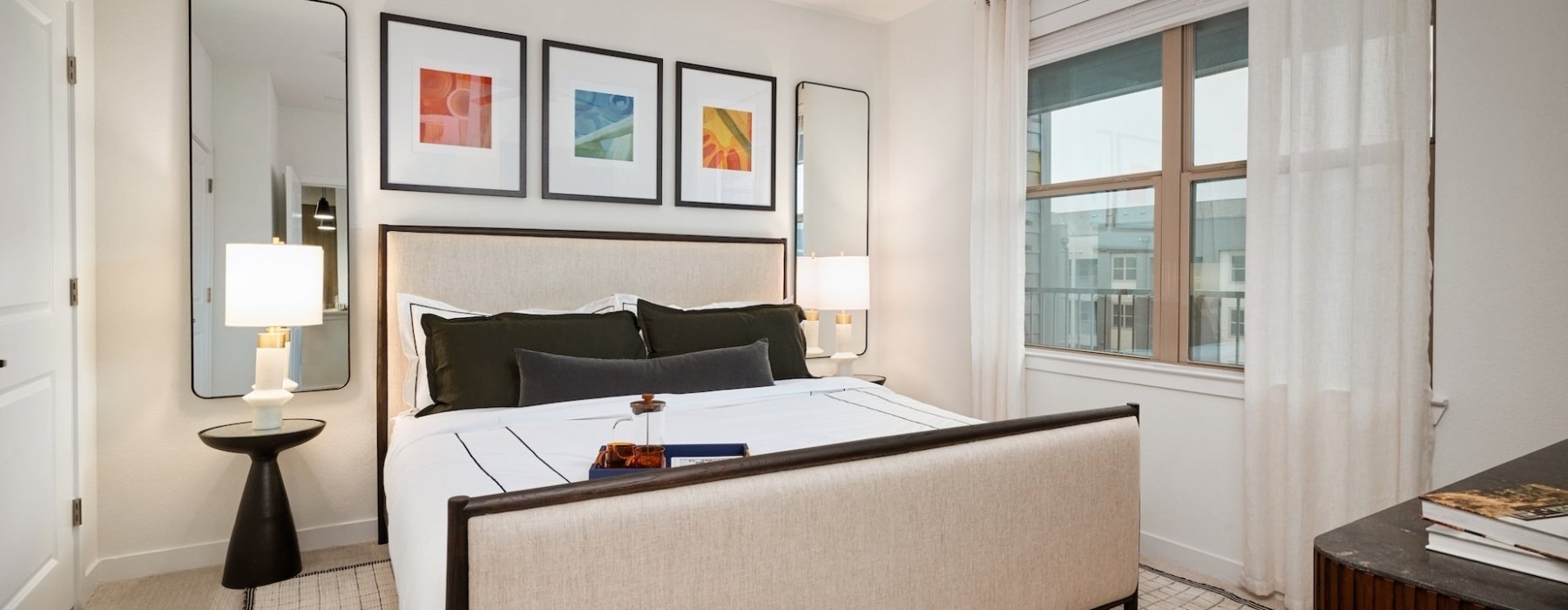 bedroom with a bed with two nightstands both with lamps and a dresser