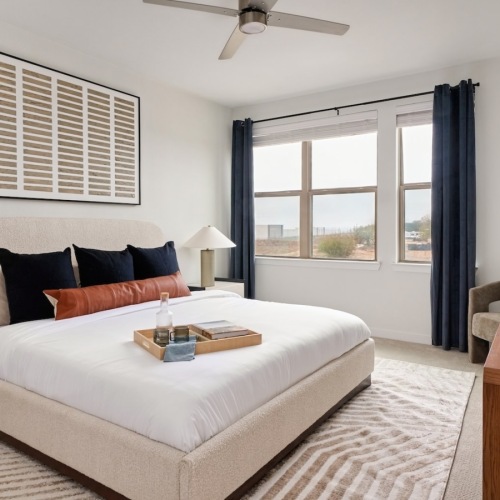 large well lit bedroom with a bed and dresser 