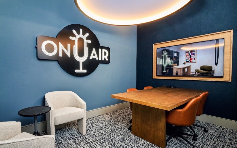podcast rrom with a table and chars with a sign on the wall that says on air