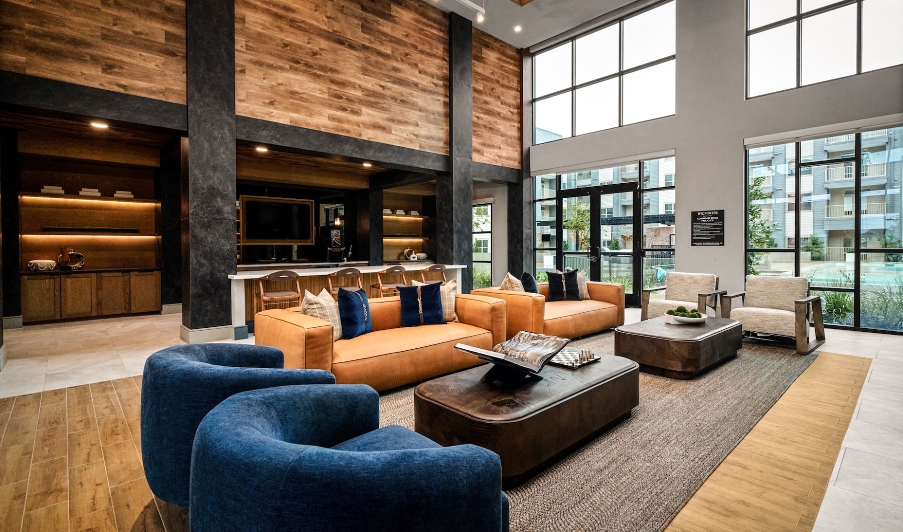 a two story room with floor to ceiling windows and ample seating