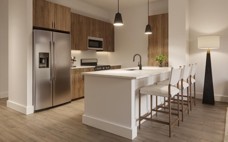 a kitchen with bar stools and a refrigerator